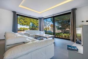 a living room with white furniture and large windows at Naturamar in Muro