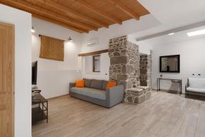 a living room with a couch and a stone wall at El Blanquizal B in San Nicolás
