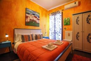 a bedroom with an orange bed with towels on it at Bnb Sottosopra intero 3 stanze 8pax in Gallipoli