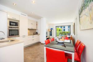 a kitchen and dining room with a table and red chairs at Bergantin 7 in Port de Pollensa