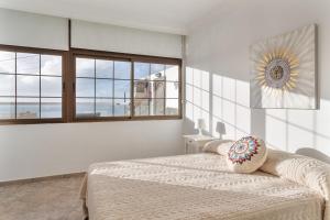 a bedroom with a bed and a large window at Crisol Apartamento in Puerto de la Madera