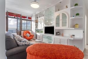 a living room with a couch and a tv at Crisol Apartamento in Puerto de la Madera