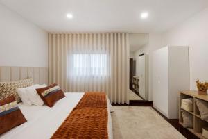 a bedroom with a large bed and a window at Casa São Domingos 1 in Lousada +27 photos