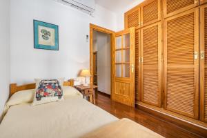 a bedroom with two beds and wooden doors at Casa El Naranjo Azul Granada in Lecrin