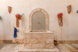 a stone wall with a window and flowers on a wall at Casa El Naranjo Azul Granada in Lecrin +24 photos