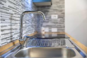 a sink with a faucet in a kitchen at Emmeci House in Alghero +16 photos