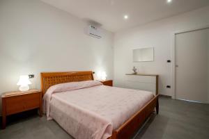 a bedroom with a large bed and two night stands at Emmeci House in Alghero