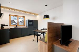 a kitchen and dining room with a table and a television at Appartement Mia in San Genesio Atesino