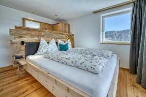 a bedroom with a large bed and a window at Hinterrainer Nature Apartments- New in Avelengo