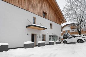 a car parked outside of a building in the snow at Appartement Mia in San Genesio Atesino