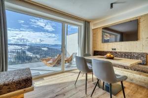 a dining room with a table and chairs and a large window at Hinterrainer Nature Apartments- New in Avelengo