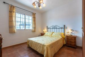 a bedroom with a bed and a window at Chalet andaluz Los Alberos in Coín