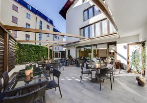 a patio with tables and chairs in a building at Residence Alpenrose in Col di Villa