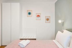 a white bedroom with a bed with a towel on it at Dal Pernè in Volastra