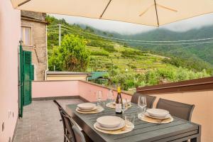 a table with glasses and a bottle of wine on a balcony at Dal Pernè in Volastra