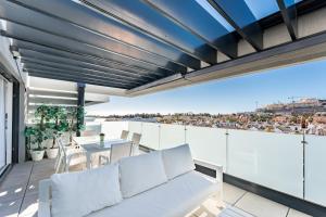 a balcony with a white couch and a table at 250 La Cala Calaserena in La Cala de Mijas