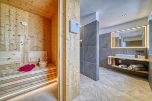a bathroom with a tub with a sink and a mirror at Hinterrainer Nature Apartments- New in Avelengo +44 photos