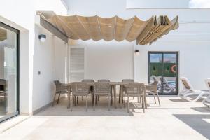 a dining room with a table and chairs on a patio at Villa Sam 3 in Can Picafort