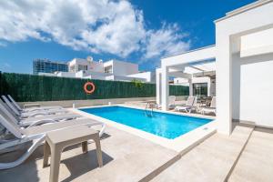 a villa with a swimming pool and patio furniture at Villa Sam 3 in Can Picafort