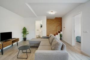 a living room with a couch and a tv at Casa Do Tempo com Jacuzzi in Ribeira Brava