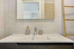 a bathroom with a white sink and a mirror at Casa Do Tempo com Jacuzzi in Ribeira Brava +23 photos