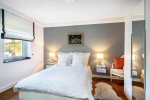 a bedroom with a white bed and two lamps at Ferienwohnung Aachen Süd in Aachen