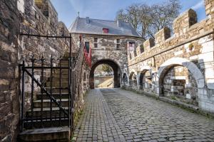 an entrance to an old stone building with a gate at Ferienwohnung Aachen Süd in Aachen