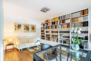 a living room with a large bookshelf at Ferienwohnung Aachen Süd in Aachen
