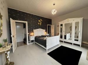 a bedroom with a bed and two tables and mirrors at Chambre D'hôte - Le Chalêt in Ygrande