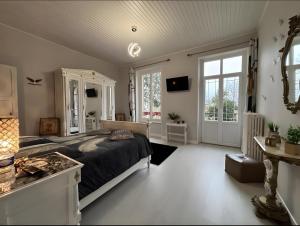 a large bedroom with a large bed and windows at Chambre D'hôte - Le Chalêt in Ygrande