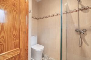 a bathroom with a toilet and a glass shower at Casa Cinta in Deltebre +17 photos
