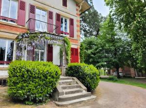 a house with a red door and stairs in front at Chambre D'hôte - Le Chalêt in Ygrande +13 photos