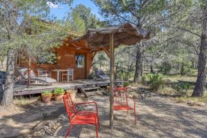 a cabin with two red chairs and an umbrella at Awa Natura in Aigues