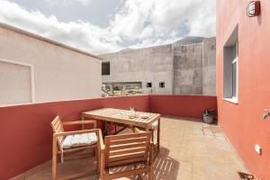 an outdoor patio with a wooden table and chairs at Jimaguas in Tamaduste