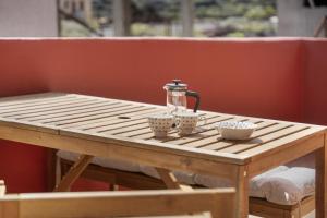 a wooden table with three cups and affeepot on it at Jimaguas in Tamaduste