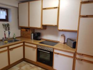 a kitchen with wooden cabinets and a stove top oven at Fewo Schwarz in Ettenheim