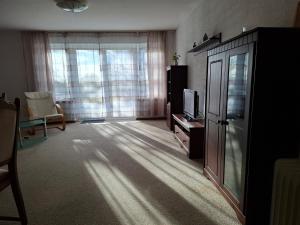 a living room with a tv and a large window at Fewo Schwarz in Ettenheim