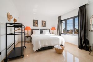 a bedroom with a white bed and a large window at Villa Flores in Marbella +17 photos