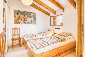 two beds in a room with a chair and a painting at Casa amarilla del mar piso 3y4 in Villajoyosa