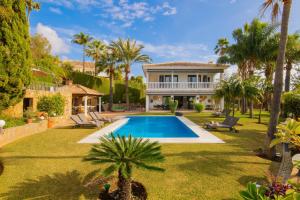 a backyard with a swimming pool and a house at Villa Flores in Marbella