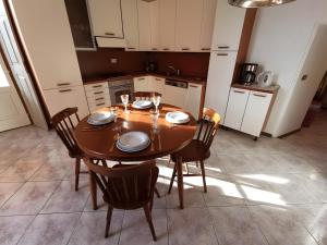 a kitchen with a wooden table and chairs with glasses at Spacious Historic Apartment F1 in Gravedona +22 photos