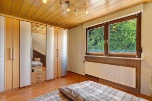 a bedroom with a large window and a bed at Wohung zum Ausblick in Plettenberg