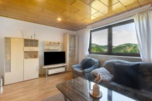 a living room with a couch and a tv at Wohung zum Ausblick in Plettenberg