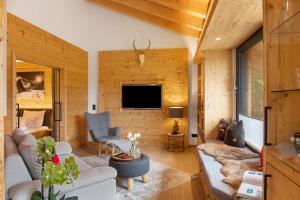 a living room with a couch and a tv at Alpenchalet 19 in Krün
