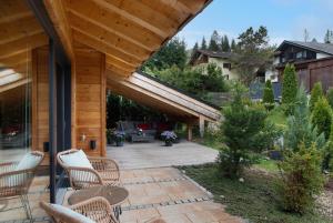 a patio with wicker chairs and tables on a house at Alpenchalet 19 in Krün