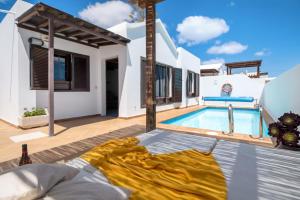a villa with a swimming pool and a bed at Villa Princesa Faina in Tías