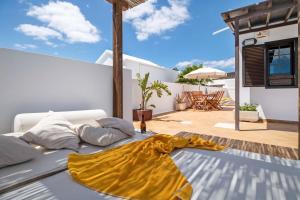 a bed with a yellow blanket sitting on a patio at Villa Princesa Faina in Tías