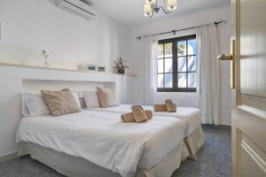 a bedroom with a large white bed with two slippers on it at Villa Princesa Faina in Tías