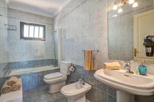 a bathroom with a toilet and a sink and a tub at Villa Princesa Faina in Tías +19 photos