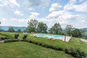a swimming pool in the middle of a grass field at Il Serrino 4 in Pistoia